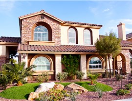 exterior of 2-story brick and plaster house with big curved windows