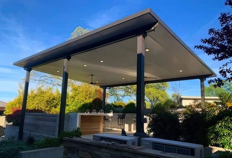 Freestanding Temo patio cover with solid roof over an outdoor patio and kitchen