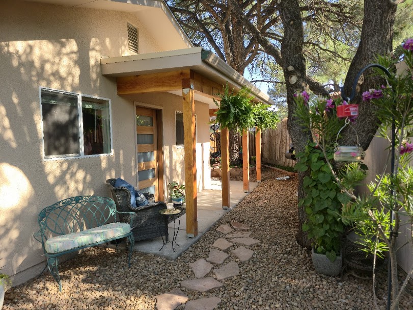 Stucco home exterior with a shaded patio and garden