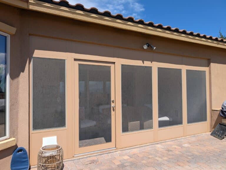 Color-matched sunroom enclosure on a stucco home