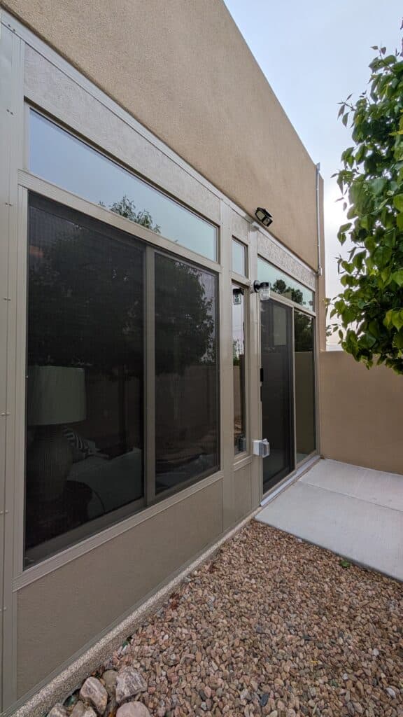 Sunroom windows and entry beside a stucco home