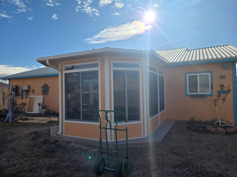 Painted sunroom addition on a stucco home