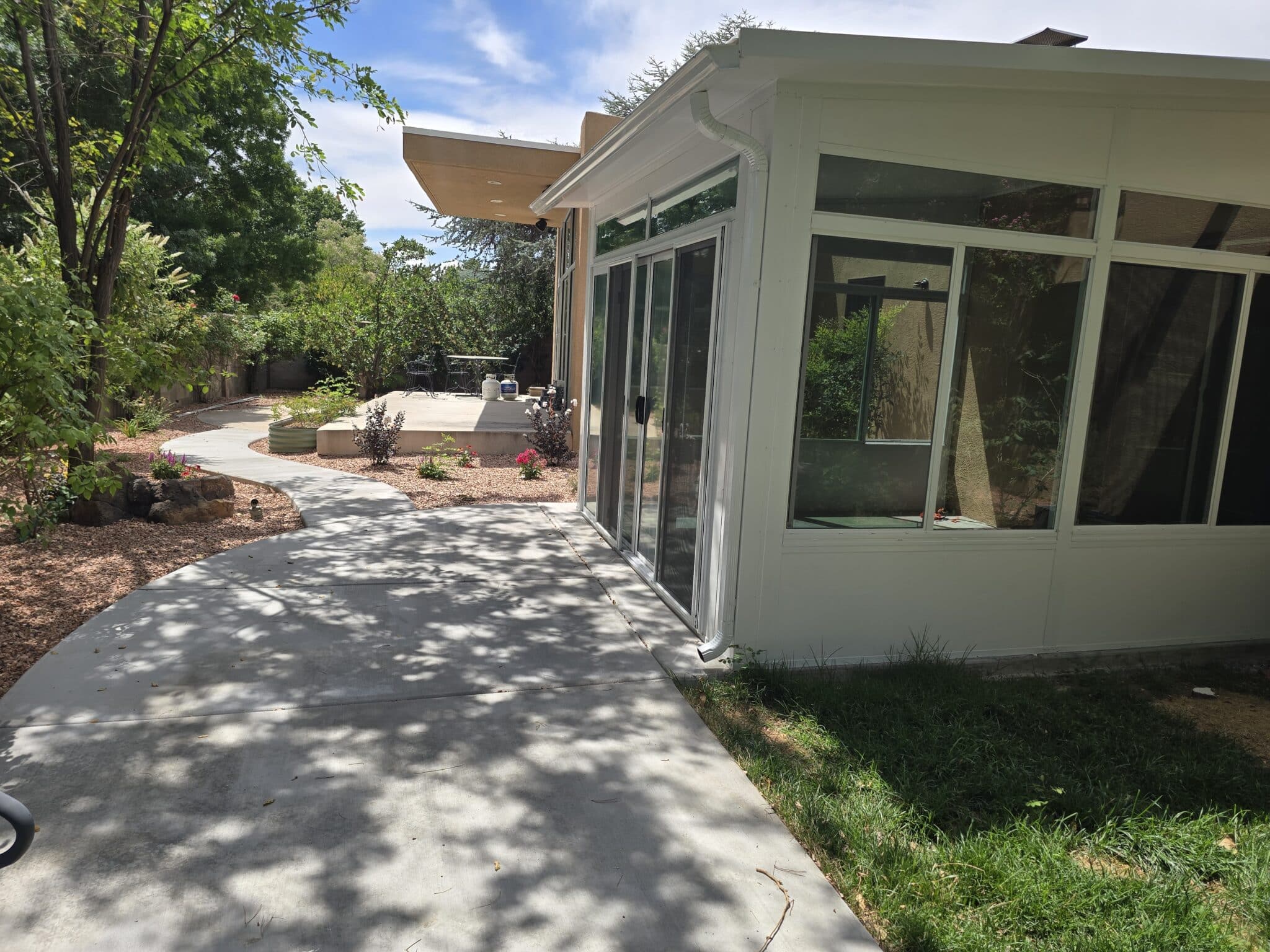 Custom sunroom beside a landscaped patio