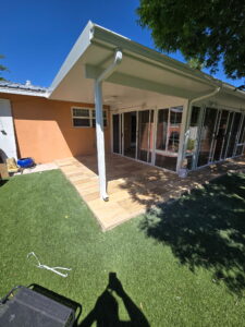 Sunroom exterior beside a tiled patio and lawn