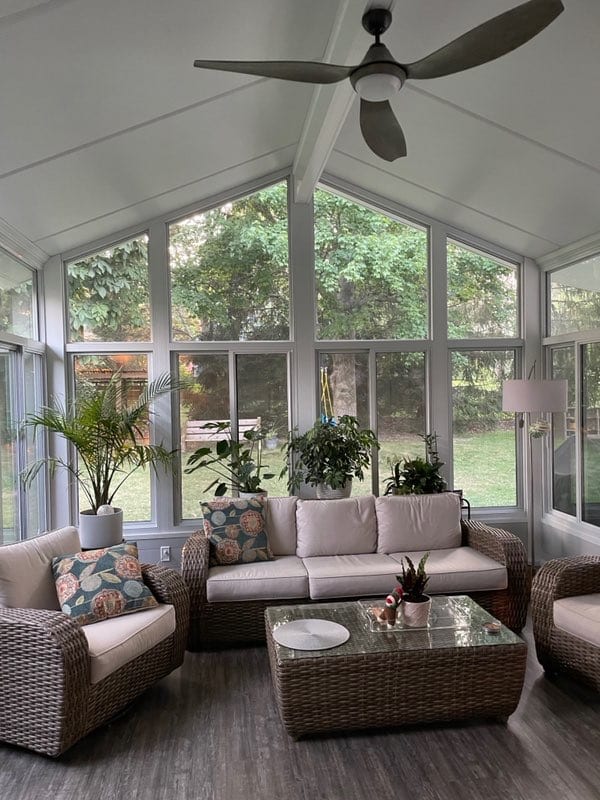 Gabled sunroom interior with seating and a ceiling fan