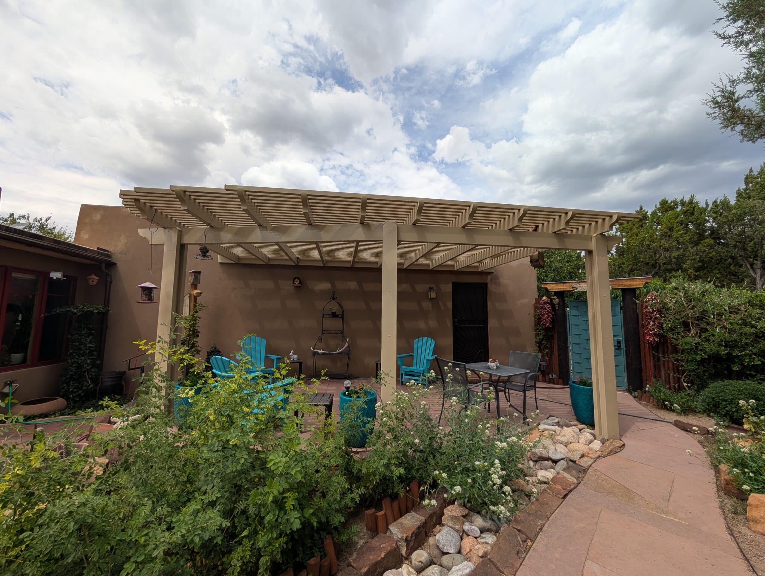 Turquoise-trimmed lattice patio cover with garden plants