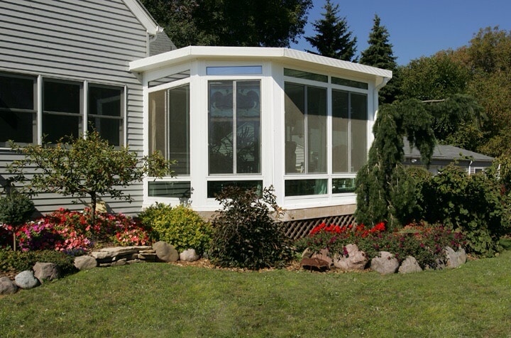 White studio sunroom overlooking a garden